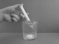 Slowly push the oral syringe plunger all the way down to empty the water from the oral syringe straight into the cup containing the VIGPODER Illustration